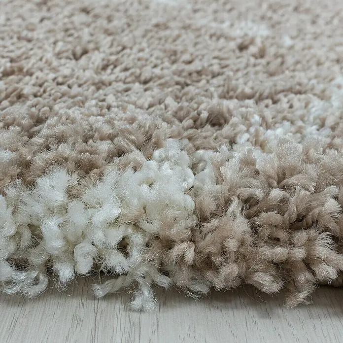 Hochflorteppich Salsa 3201Beige, Durchmesser: 120 cm, 100% Polypropylen - Nahaufnahme eines beigen, hochflorigen Teppichs mit weißen Akzenten, der eine weiche und einladende Textur zeigt.
