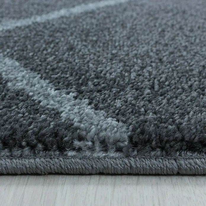 Hochflorteppich Rio 4602Grau, 250 x 80 cm, 100% Polypropylen - Nahaufnahme eines grauen Teppichs mit abstraktem Muster, der eine weiche und luxuriöse Textur zeigt.