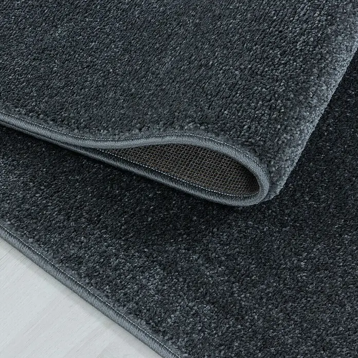 Hochflorteppich Rio 4600 - Grau, 150 x 80 cm, 100% Polypropylen - Nahaufnahme eines grauen Teppichs mit gewebter Unterseite und sauberem Rand.