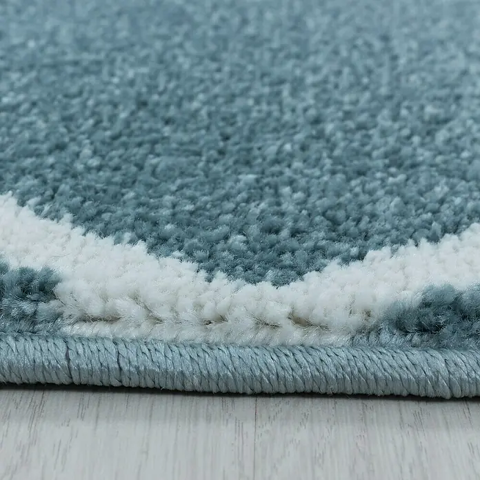 Hochflorteppich Rio 4601Blau, 150 x 80 cm, 100% Polypropylen - Nahaufnahme eines weichen, hellblauen Teppichs mit weißem Muster. Die Textur ist flauschig und einladend.