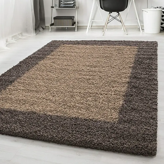 Hochflorteppich Life 1503Taupe, 110 x 60 cm, 100 % Polypropylen - Ein rechteckiger, mehrfarbiger Teppich mit einem hellbraunen Mittelteil und einem dunkelbraunen Rand liegt auf einem hellen Boden.