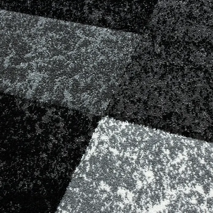 Kurzflorteppich Hawaii 1330 - Schwarz, 170 x 120 cm, 100% Polypropylen - Nahaufnahme eines modernen Teppichs in Schwarz- und Grautönen. Das geometrische Muster und die Textur des Teppichs sind gut erkennbar.