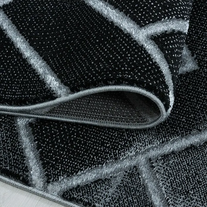 Kurzflorteppich Naxos 3814Silber, 200 x 140 cm, 80% Polypropylen, 20% Polyester - Nahaufnahme eines modernen Teppichs mit abstraktem, geometrischem Muster in Schwarz und Grau, der eine stilvolle Textur und Design zeigt.