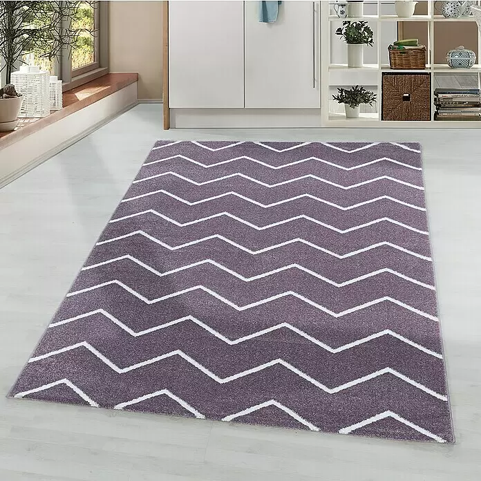 Hochflorteppich Rio 4602 - Lila, 250 x 80 cm, 100% Polypropylen - Ein rechteckiger violetter Teppich mit weißem Zickzackmuster liegt auf hellem Holzboden in einem modernen Raum.