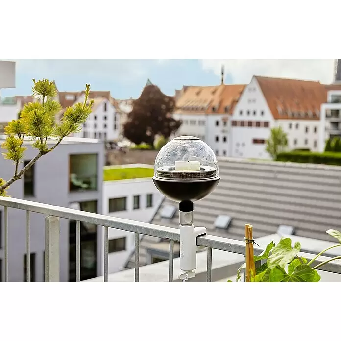 Gardena ClickUp! Windlicht - Ø x H: 15,4 x 19,7 cm, Schwarz - Kugelförmiger Outdoor-Kerzenhalter mit transparentem Oberteil und schwarzem Fuß, an Balkongeländer geklemmt. Eine weiße Kerze ist darin.