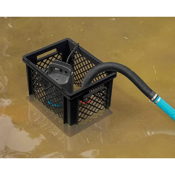 Gardena Schmutzwasserpumpe 9000 Hochwasser-Set - 300 W, Max. Fördermenge: 9.000 l/h, Eintauchtiefe: 7 m - Eine Tauchpumpe in einem schwarzen Korb steht im Wasser und ist mit einem blauen Schlauch verbunden.