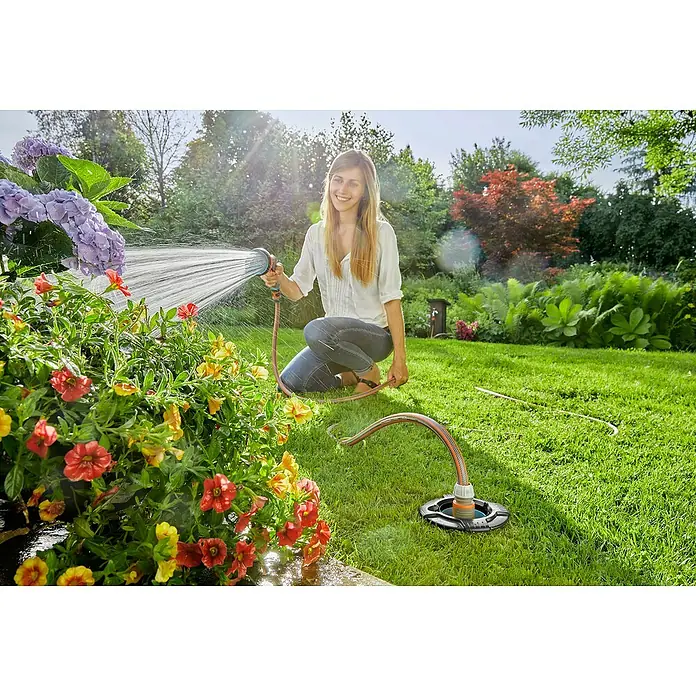 Gardena Sprinklersystem Bewässerungs-Set Pipeline Start-Set - 9 -tlg. - Frau bewässert Gartenpflanzen mit dem Gardena Bewässerungssystem. Das System ist einfach zu bedienen und spart Wasser.
