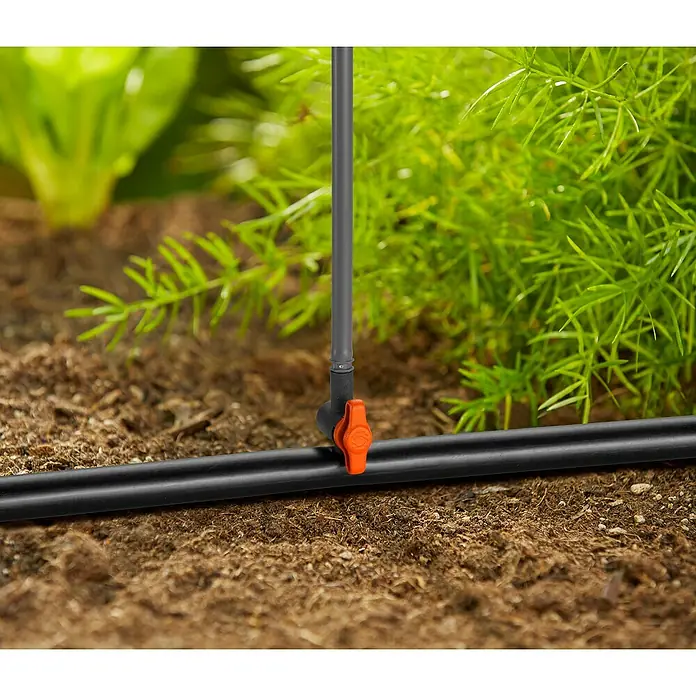 Gardena Micro-Drip Regulierventil - Passend für: Gardena Sprühdüsen (1396, 1367, 1368, 1370, 1372, 1371), 5 Stk. - Nahaufnahme einer Bewässerungsanlage im Garten mit schwarzem Schlauch und orangenem Ventil zur Regulierung der Wasserzufuhr.
