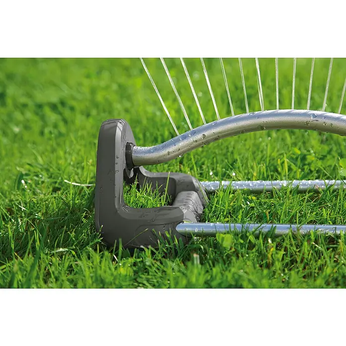Gardena Aspersor oscilante Aqua S - Superficie de rociador máx.: 220 m² - Primer plano de un aspersor de césped, irrigando un césped verde con chorros de agua claros.