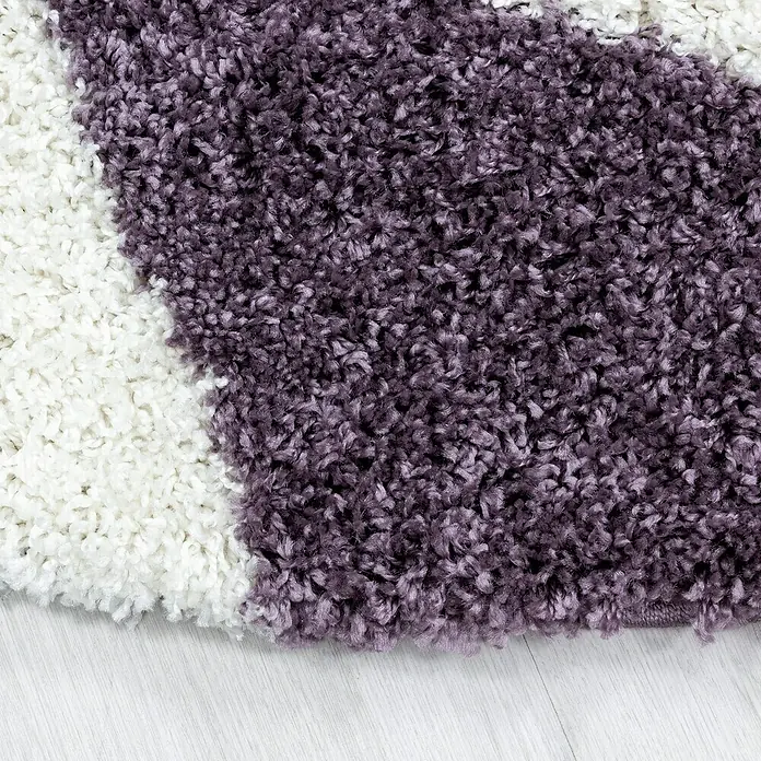 Hochflorteppich Tango 3101Lila, 200 x 140 cm, 100% Polypropylen - Nahaufnahme eines mehrfarbigen Teppichs mit weichen, hochflorigen Texturen in Weiß und Lila.
