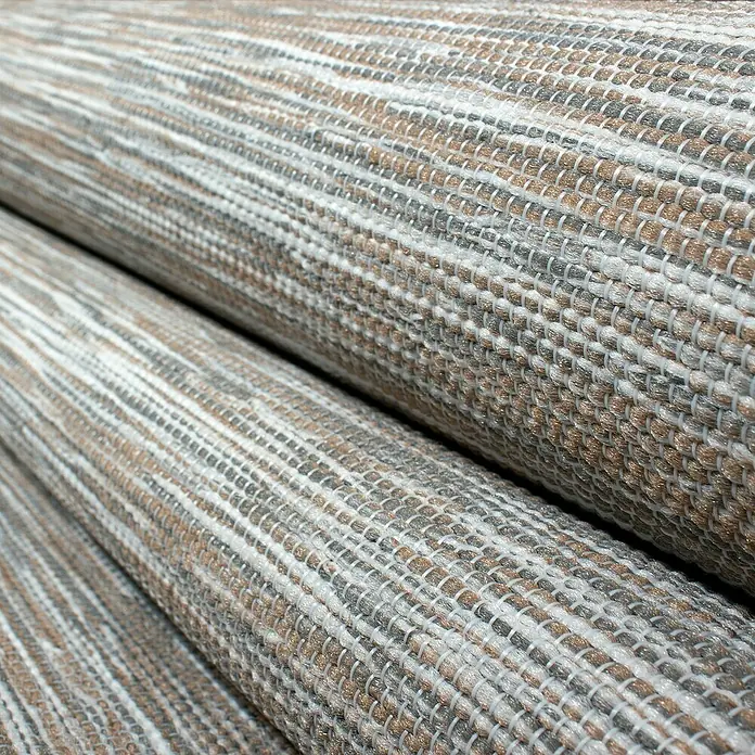 Outdoor-Teppich Mambo 2000Taupe, 150 x 80 cm, 100% Polypropylen - Nahaufnahme von Teppichrollen in verschiedenen Farben und Texturen.