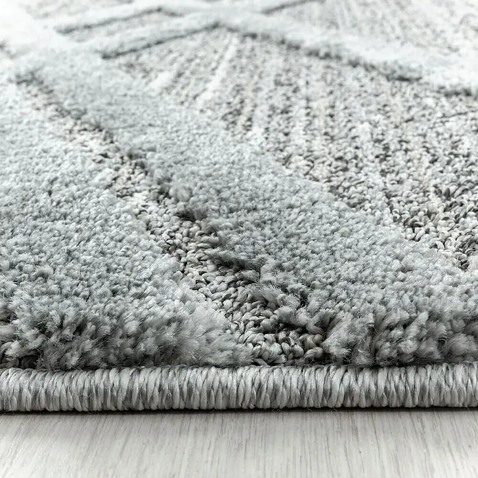 Hochflorteppich Pisa 4706Grau, Durchmesser: 120 cm, 100% Polypropylen - Nahaufnahme eines grauen Teppichs mit abstraktem Muster und flauschiger Textur, ideal für ein gemütliches Ambiente im Wohnbereich.