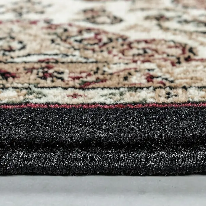 Kurzflorteppich Kashmir 2606Schwarz, 340 x 240 cm, 100% Polypropylen - Nahaufnahme eines Teppichs mit klassischem Muster und schwarzem Rand, der eine elegante Note verleiht. Dieser Teppich ist vielseitig und stilvoll.
