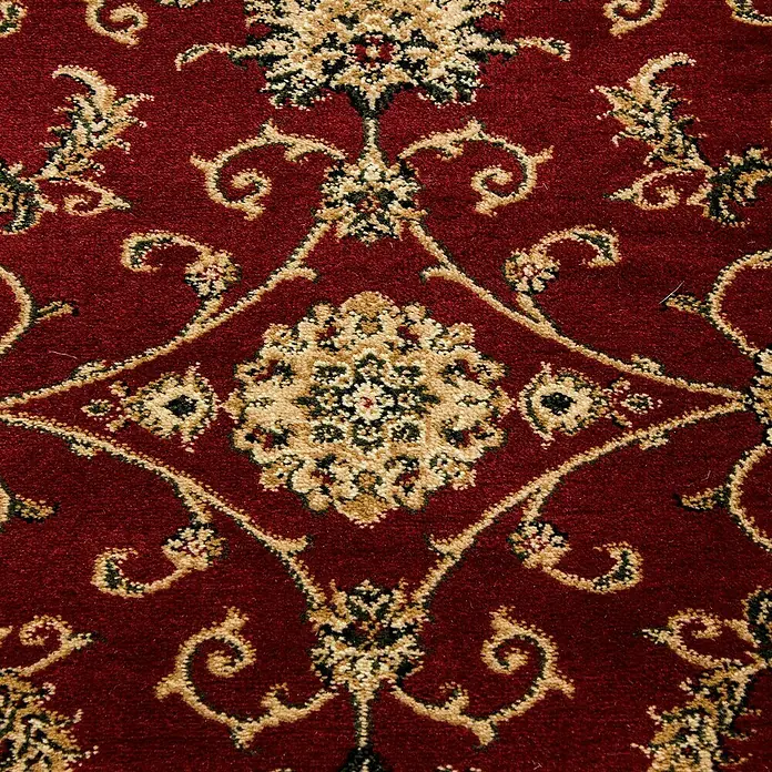 Kurzflorteppich Orient-Optik Marrakesh 0210Rot, 170 x 120 cm, 100% Polypropylen - Nahaufnahme eines reich gemusterten, rotfarbenen Teppichs mit floralen Ornamenten in Beige und Schwarz.