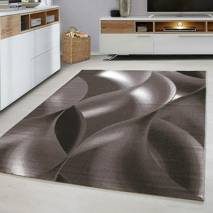 Kurzflorteppich Plus 8008Braun, 230 x 160 cm, 100 % Polypropylen - Ein moderner brauner Teppich mit einem auffälligen 3D-Wellenmuster liegt in einem hellen Raum. Der Teppich ist der Blickfang.