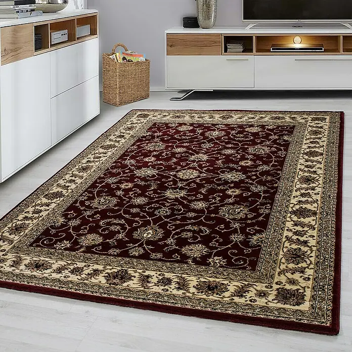 Kurzflorteppich Orient-Optik Marrakesh 0210 - Rot, 230 x 160 cm, 100% Polypropylen - Ein detailreicher, rot gemusterter Teppich mit einem beigen Rand liegt auf einem hellen Holzboden.