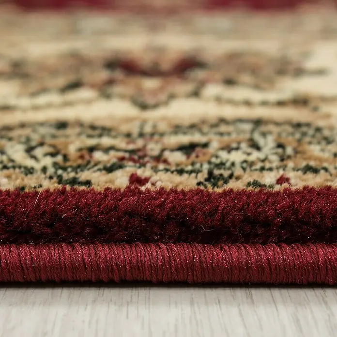 Kurzflorteppich Orient-Optik Marrakesh 0210 - Rot, 230 x 160 cm, 100% Polypropylen - Nahaufnahme eines fein gearbeiteten Orientteppichs mit floralem Muster und rotem Rand, der die hochwertige Textur und das detaillierte Design hervorhebt.