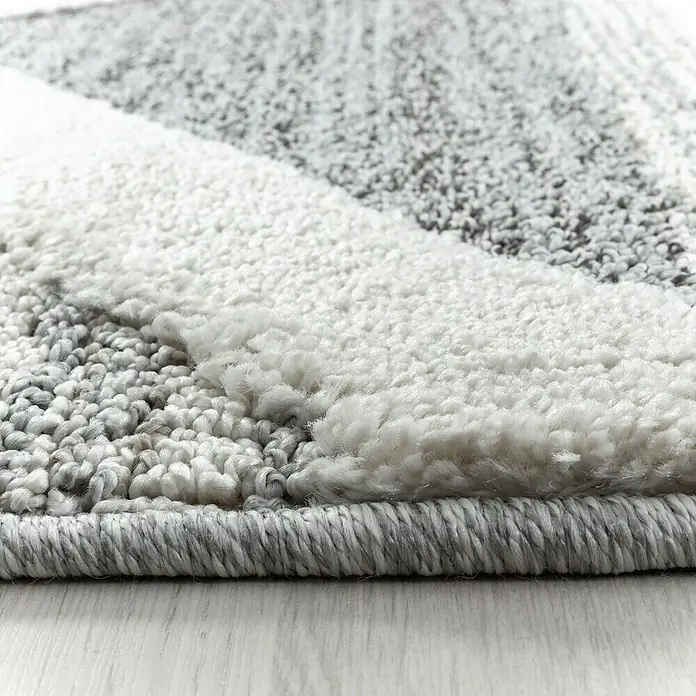 Hochflorteppich Pisa 4709 - Grau, Durchmesser: 120 cm, 100% Polypropylen - Nahaufnahme eines modernen Teppichs mit abstraktem Muster in Grau- und Weißtönen, der eine weiche Textur und hochwertige Verarbeitung zeigt.