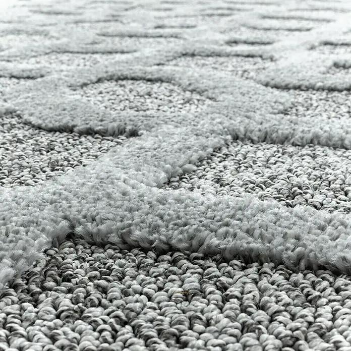 Hochflorteppich Pisa 4702 - Grau, Durchmesser: 200 cm, 100% Polypropylen - Nahaufnahme eines grauen Teppichs mit erhabenem Muster, der Textur und Komfort für jeden Raum bietet.