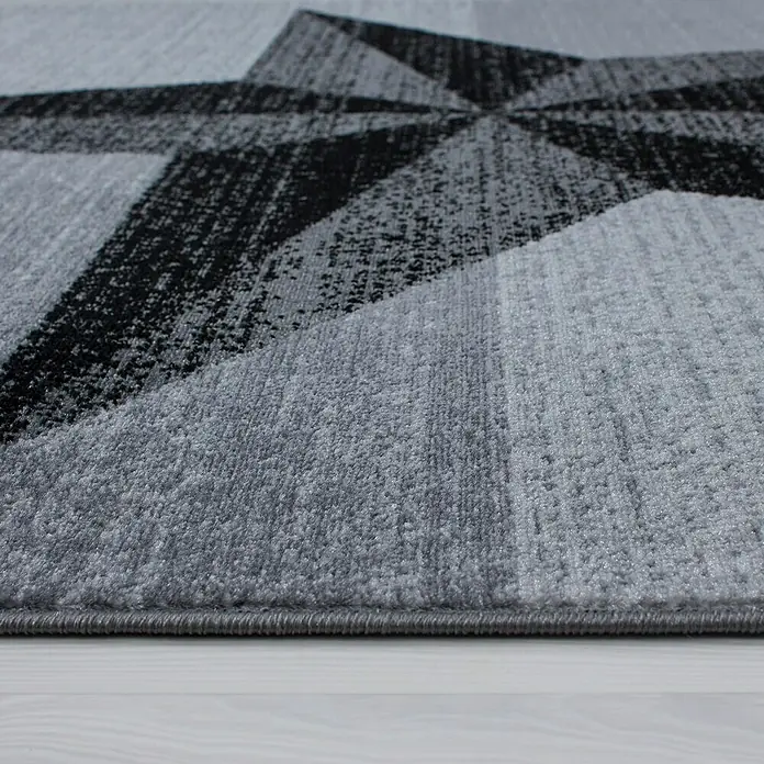 Kurzflorteppich Plus 8002 - Grau, 230 x 160 cm, 100% Polypropylen - Nahaufnahme eines grauen Teppichs mit abstraktem geometrischen Muster.