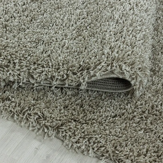 Hochflorteppich Sydney 3000 - Natur, 170 x 120 cm, 100% Polypropylen - Nahaufnahme eines beigen Shaggy-Teppichs, der seine weiche Textur und den gewebten Rücken zeigt. Ideal für Wohnzimmer und Schlafzimmer.
