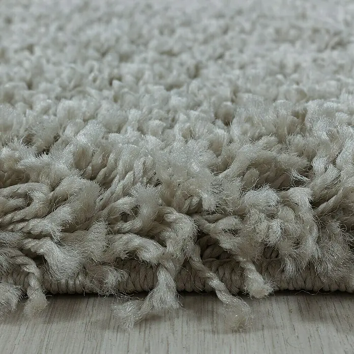 Hochflorteppich Sydney 3000 - Natur, 170 x 120 cm, 100% Polypropylen - Nahaufnahme eines cremefarbenen Shaggy-Teppichs, der eine weiche und luxuriöse Textur für den Wohnbereich bietet.