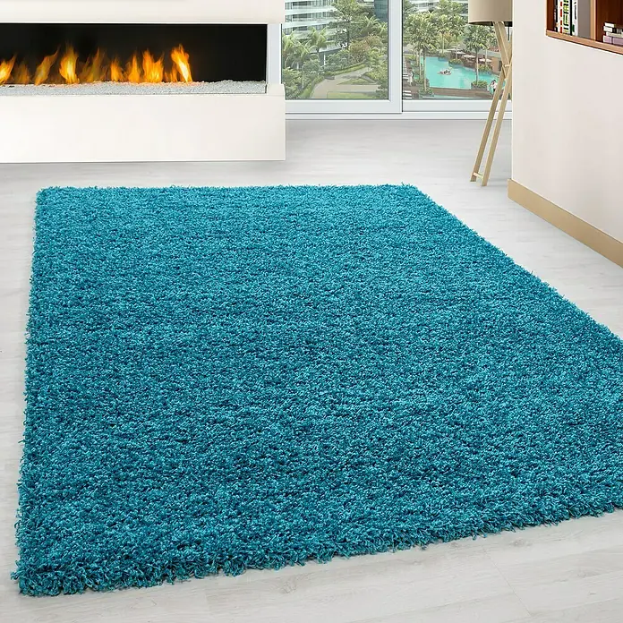 Hochflorteppich Life 1500Türkis, 150 x 80 cm, 100 % Polypropylen - Türkisblauer, hochfloriger Teppich im Wohnzimmer vor Kamin und Fenster.