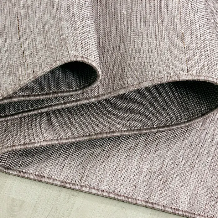Outdoor-Teppich Mambo 2000Pink, 250 x 80 cm, 100 % Polypropylen - Nahaufnahme eines gewebten Teppichs mit umgeschlagenen Kanten, der die Textur und Verarbeitung des Teppichs hervorhebt.