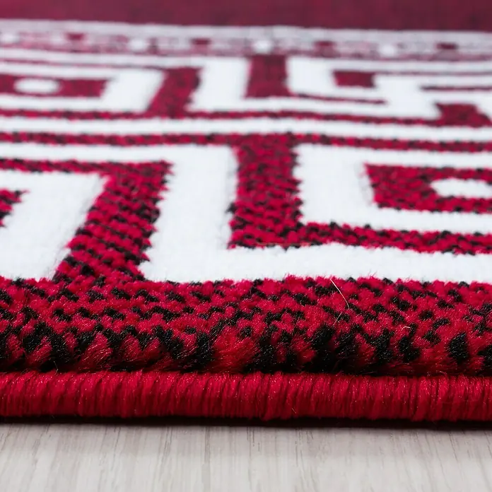 Kurzflorteppich Parma 9340 - Rot, 170 x 120 cm, 100% Polypropylen - Nahaufnahme eines roten Teppichs mit einem weißen, geometrischen Mäandermuster.