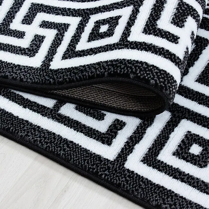 Kurzflorteppich Parma 9340 - Schwarz, 290 x 200 cm, 100% Polypropylen - Nahaufnahme eines Teppichs mit geometrischem Muster in Schwarz und Weiß, der eine moderne Note verleiht.