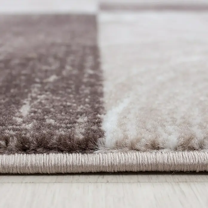 Kurzflorteppich Parma 9220Braun, 170 x 120 cm, 100% Polypropylen - Nahaufnahme eines Teppichs mit abstraktem Muster und braunen und weißen Farbtönen, der Textur und Design hervorhebt.