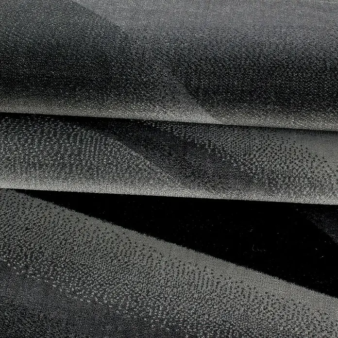 Kurzflorteppich Miami - Schwarz, 200 x 140 cm, 100 % Polypropylen - Nahaufnahme von gefaltetem, dunklem Stoff mit subtiler Textur, ideal für hochwertige Möbel oder Bekleidung. Eleganz und Komfort vereint.