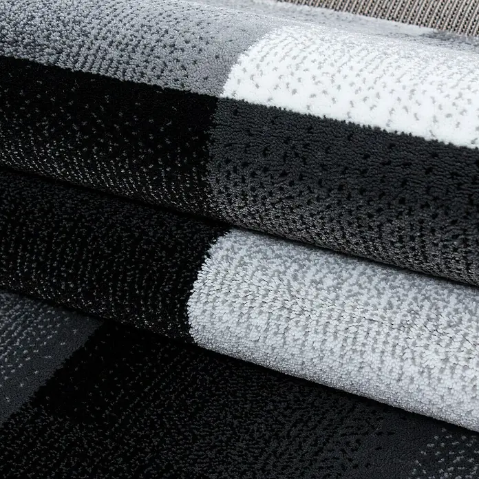 Kurzflorteppich Miami 6560 - Schwarz, 150 x 80 cm, 100% Polypropylen - Nahaufnahme eines mehrfarbigen Teppichs mit weicher Textur und Farbverlauf von Grau zu Schwarz und Weiß.
