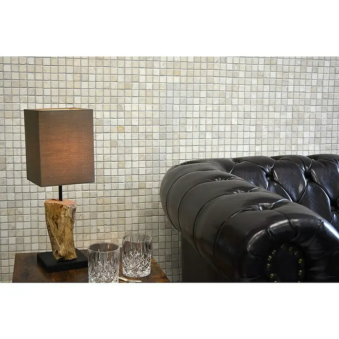 Mosaikfliese Quadrat Uni MOS TN23W - 30,5 x 30,5 cm, Cremeweiß, Matt - Nahaufnahme eines Interieurs mit einer stilvollen Lampe und einem eleganten Ledersofa vor einer Mosaikwand.