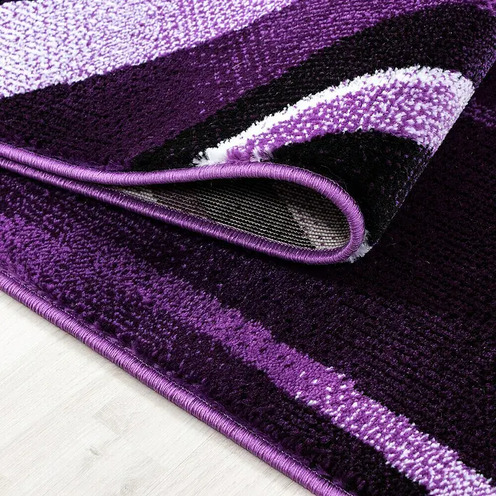 Kurzflorteppich Parma 9210Lila, 150 x 80 cm, 100% Polypropylen - Nahaufnahme eines gestreiften Teppichs in Lila-, Schwarz- und Weißtönen, der eine weiche Textur und eine dekorative Bordüre aufweist.