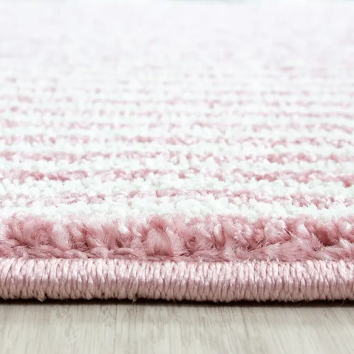 Kinderteppich Kids 0620 - Pink, 200 x 140 cm, 100 % Polypropylen - Nahaufnahme eines weichen, rosa-weiß gestreiften Teppichs, der Textur und Komfort betont. Ideal für gemütliche Wohnräume.