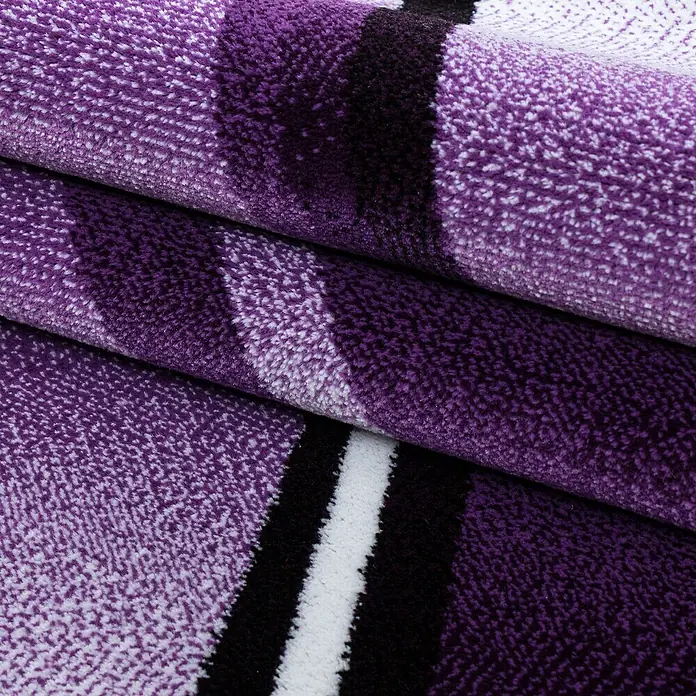Kurzflorteppich Parma 9210Lila, 150 x 80 cm, 100% Polypropylen - Nahaufnahme eines lila Teppichs mit Streifenmuster, der eine weiche Textur und ein modernes Design aufweist.