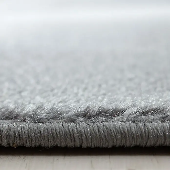 Kurzflorteppich Parma 9310Schwarz, 170 x 120 cm, 100% Polypropylen - Detailaufnahme eines grauen Teppichs mit weicher Textur, die die Qualität und den Komfort des Produkts hervorhebt.