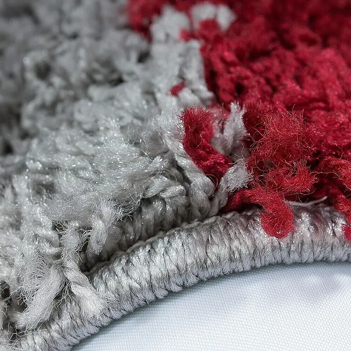 Hochflorteppich Life 1501 - Rot, 110 x 60 cm, 100% Polypropylen - Nahaufnahme eines rot-grauen Teppichs, der die Textur und die Farben des Teppichs hervorhebt. Ideal für Wohnräume, die Wärme und Stil suchen.