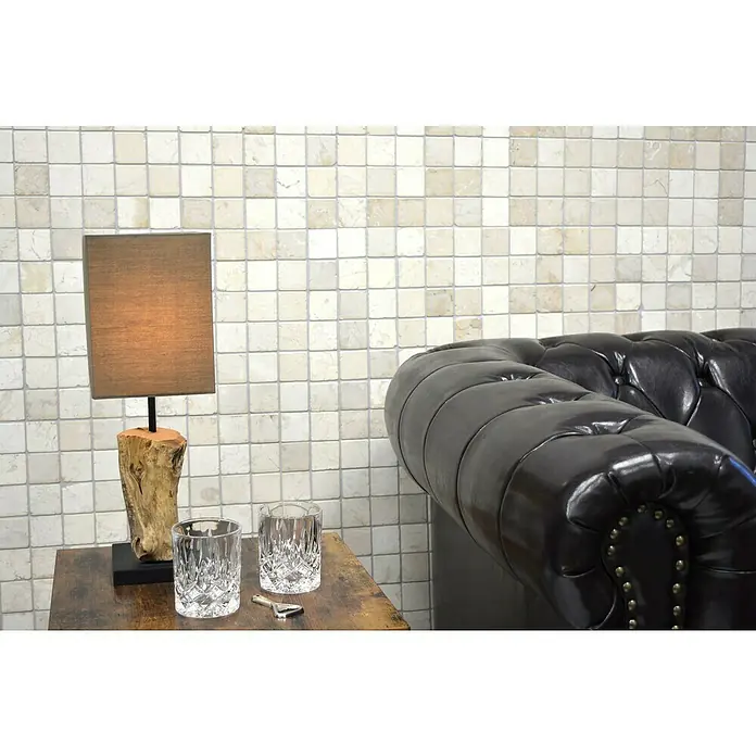 Mosaikfliese Quadrat Uni MOS TN48W - 30,5 x 30,5 cm, Cremeweiß, Matt - Ein stilvolles Interieur mit einer braunen Ledercouch und einer dekorativen Tischlampe mit Holzfuß vor einer Wand mit hellen Mosaikfliesen.