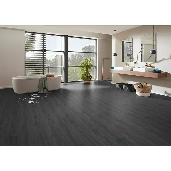 Vinylbodenmuster Strong SPC Structure Alabama - 300 x 228 x 3,8 mm, Landhausdiele - Badezimmer mit dunklem Holzboden, freistehender Badewanne und Waschtisch mit zwei Waschbecken. Große Fensterfront mit Ausblick ins Grüne.