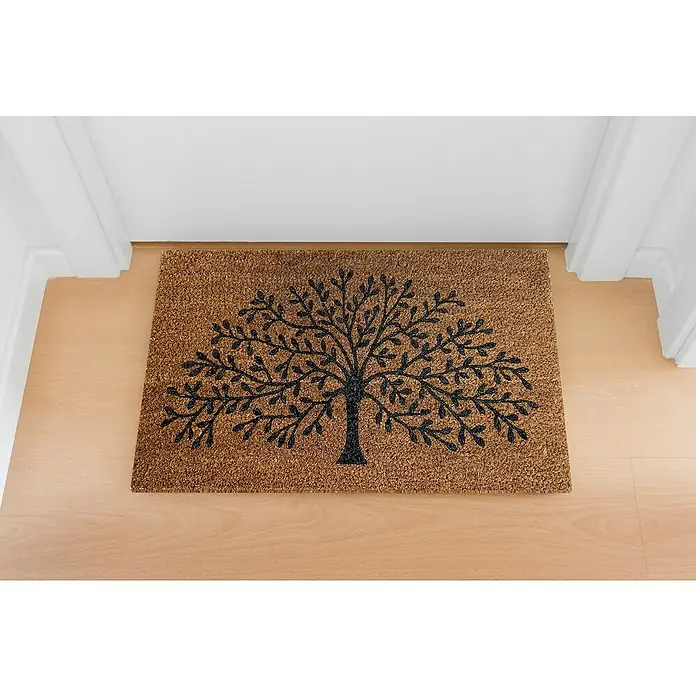 Felpudo Flocado Árbol - 70 x 40 cm, Negro/Natural - Alfombra de fibra de coco con un árbol negro estilizado, colocada en un piso de madera clara frente a una puerta blanca.