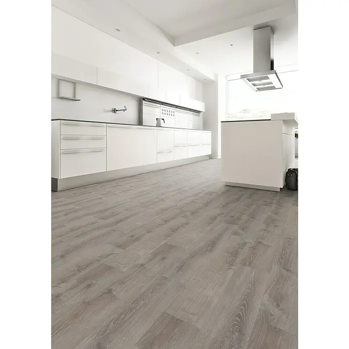 Star Clic Vinylbodenmuster More+ Smoky Oak Pewter - 280 x 160 x 3,9 mm, Landhausdiele - Elegantes Kücheninterieur mit grauem Holzboden, weißen Schränken und einer modernen Dunstabzugshaube, das ein stilvolles und zeitgemäßes Küchendesign zeigt.