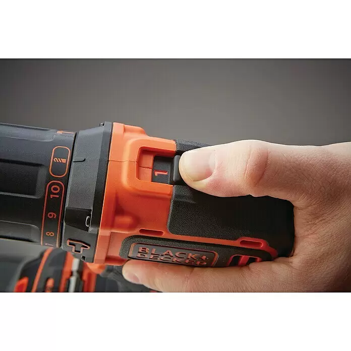 Black+Decker Taladro atornillador percutor de batería BDCHD18KB - 18 V, 2 baterías, 1,5 Ah, 40 Nm - Una mano sujeta un taladro inalámbrico Black+Decker negro y naranja. Un dedo descansa sobre el gatillo, con el interruptor de velocidad/dirección en '1'.