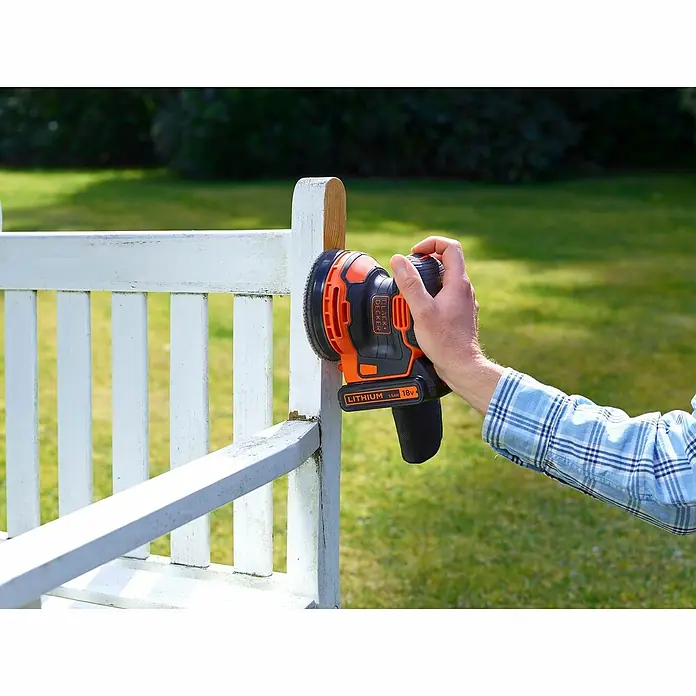 Black+Decker 18V PowerConnect Akku-Exzenterschleifer BDCROS18N-XJ - 18 V, Li-Ionen, Ohne Akku, 125 mm - Ein Black+Decker Akku-Exzenterschleifer wird zum Abschleifen einer weißen Holzbank im Freien verwendet.