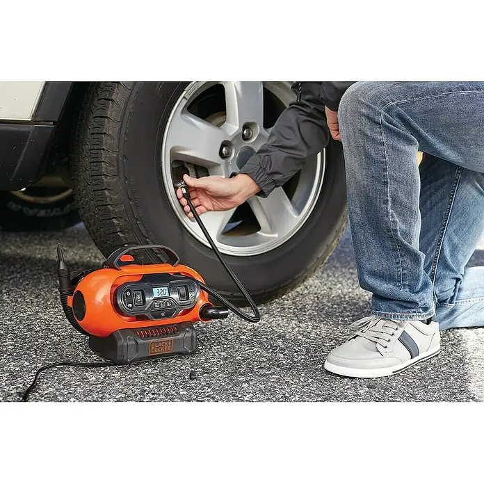 Black+Decker Akku-Kompressor BDCINF18N-QS - 18 V, Ohne Akku, 11 bar - Eine Person pumpt mit einem Black+Decker Luftkompressor einen Reifen auf.
