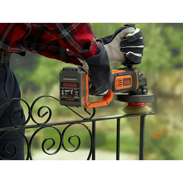 Black+Decker 18V PowerConnect Akku-Winkelschleifer BCG720N-XJ - Ohne Akku, Durchmesser Scheibe: 125 mm - Akkubetriebener BLACK+DECKER Winkelschleifer mit Drahtbürste bei der Arbeit an einem Zaun.