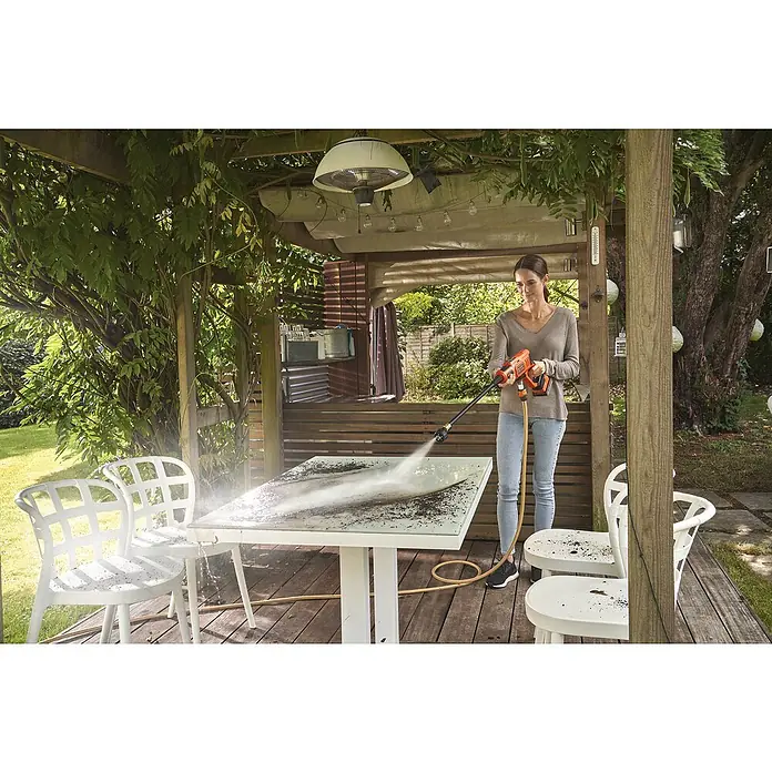 Black+Decker Akku-Druckreiniger BCPC18B - 18 V, Ohne Akku, 120 l/h - Frau reinigt Gartentisch mit BLACK+DECKER Akku-Hochdruckreiniger, um Schmutz zu entfernen. Ideal für die Gartenpflege.