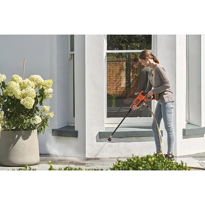 Black+Decker Akku-Druckreiniger BCPC18B - 18 V, Ohne Akku, 120 l/h - Frau benutzt einen Black+Decker-Hochdruckreiniger, um einen Außenbereich zu reinigen, wobei der Fokus auf der praktischen Anwendung des Geräts liegt.
