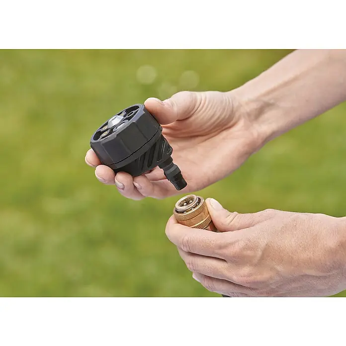 Black+Decker Akku-Druckreiniger BCPC18B - 18 V, Ohne Akku, 120 l/h - Eine Person schließt eine schwarze Sprühdüse an ein goldenes Schlauchstück an, um eine Gartenbewässerung zu ermöglichen.